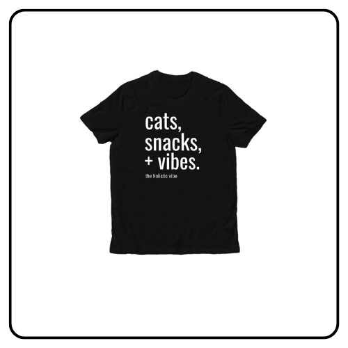 A soft black premium unisex t-shirt featuring a minimalist graphic design that reads "Cats, Snacks & Vibes" in clean, white typography.