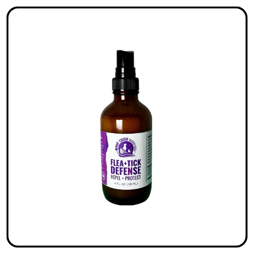 A glass bottle of Woof Creek Flea and Tick Defense Topical Spray for dogs, featuring a clean label and spray nozzle, positioned to highlight its natural, plant-based ingredients.